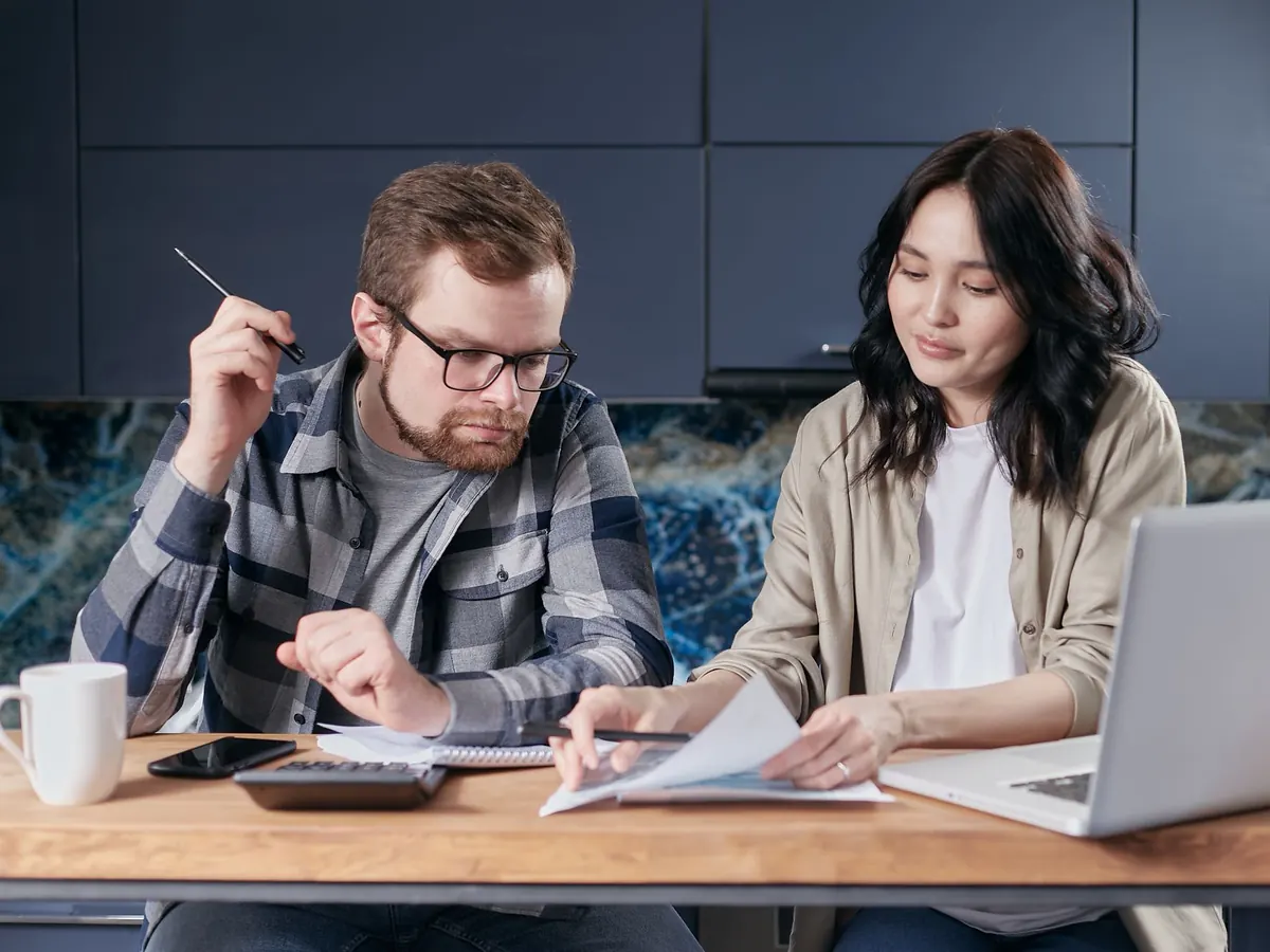 A couple sorting through tax papers together at their kitchen table